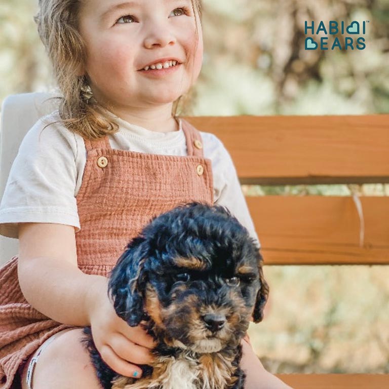 Young girl hugging a Schnoodle puppy