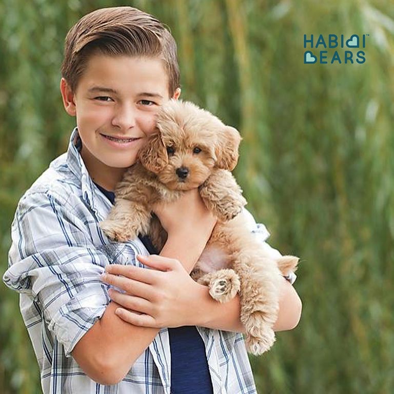 Boy holding his autism service dog, called his Familiar, in his arms