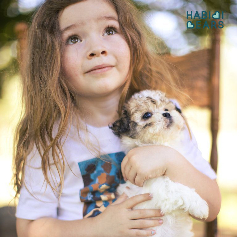 Young girl holding her autism service dog in her arms